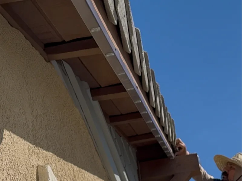 Brown low-profile permanent lighting track along wood fascia