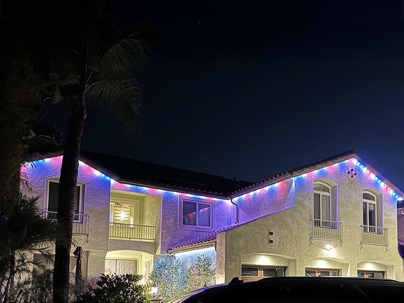 Home at night with permanent roofline lighting and color effects