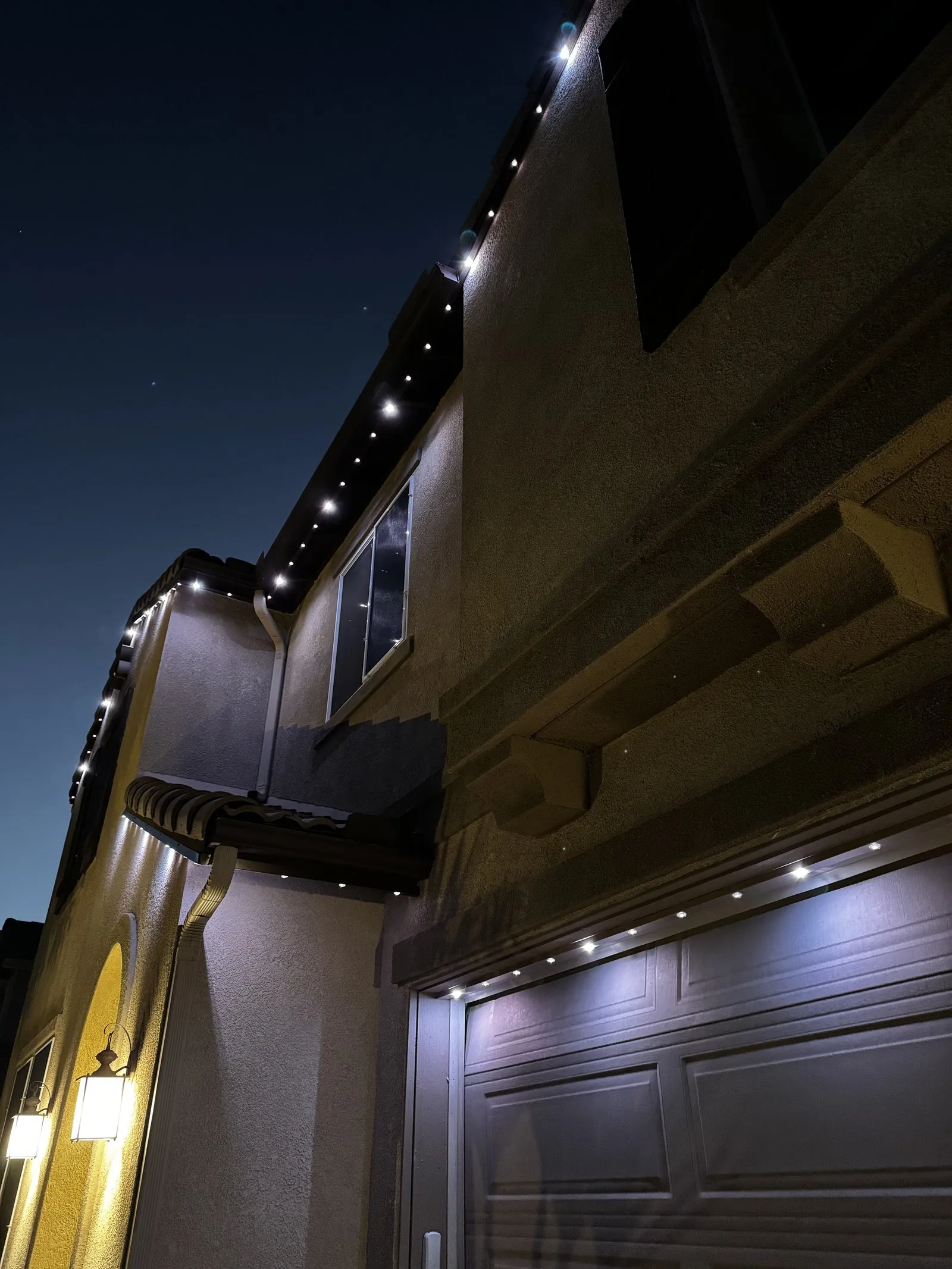 Permanent lights installed cleanly along fascia above a garage