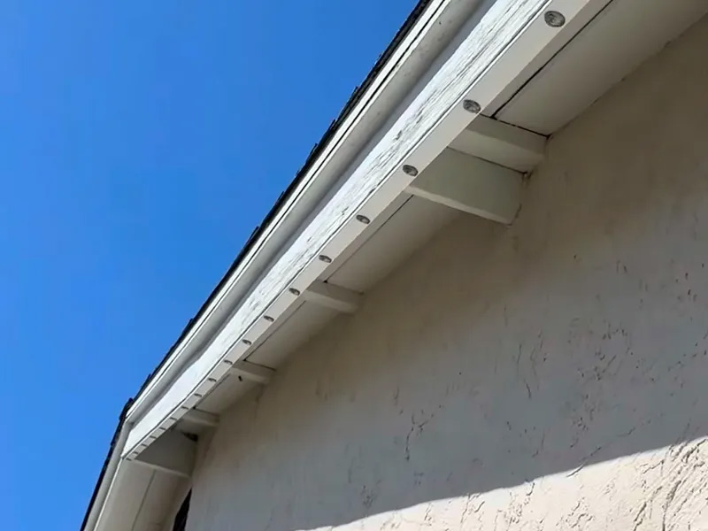 White low-profile permanent lighting track along roof fascia
